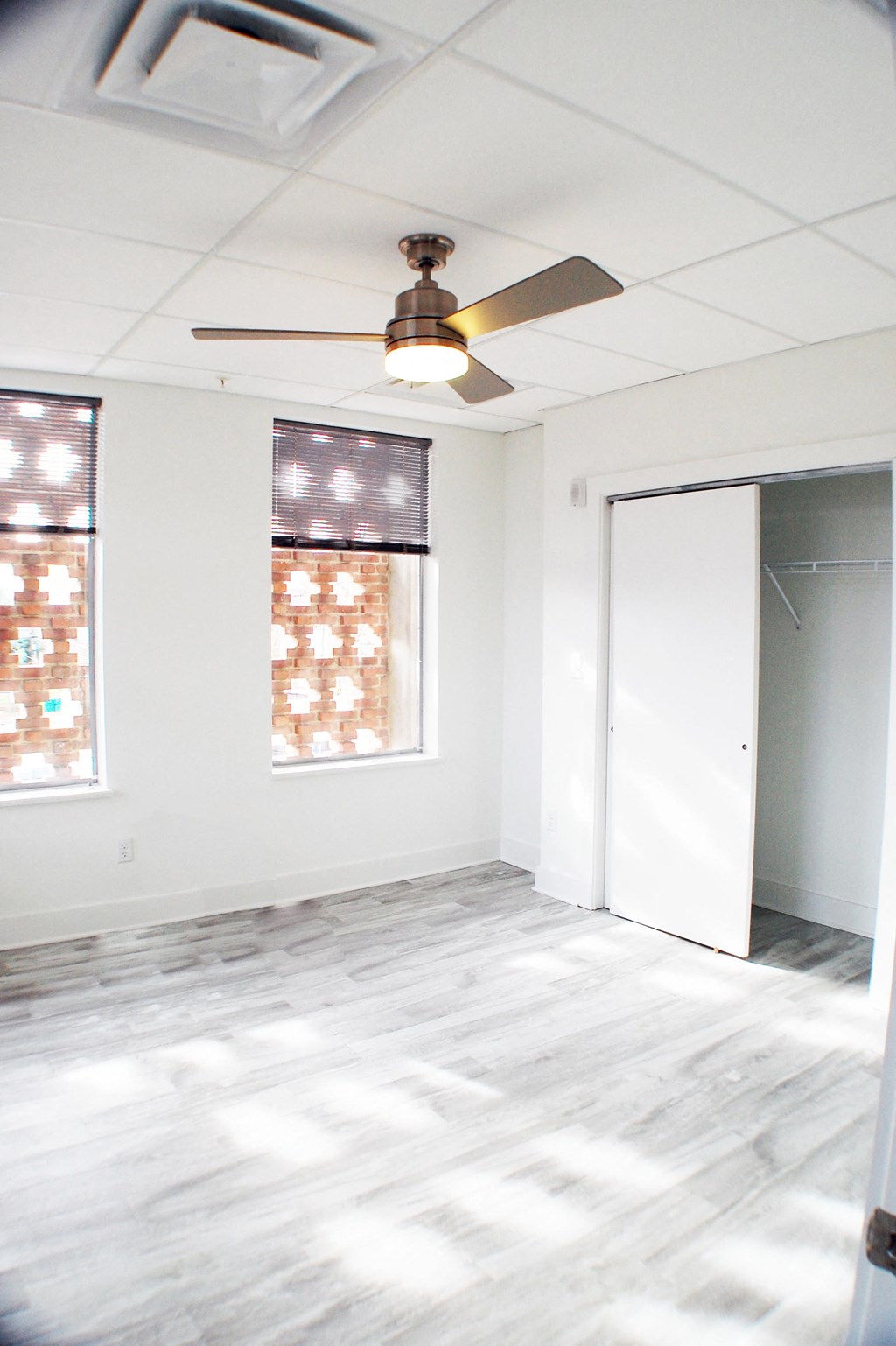 an empty room with a ceiling fan and a door