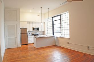 an empty kitchen with white cabinets and a window