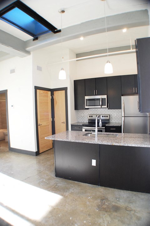 a kitchen with black cabinets and a granite counter top