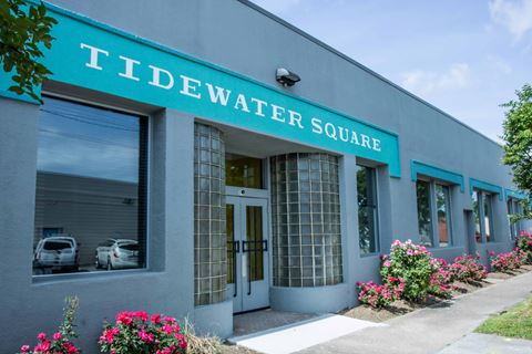 the front of the tiddwater square building with flowers outside