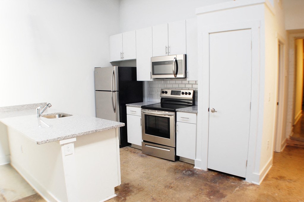 a kitchen with white cabinets and stainless steel appliances