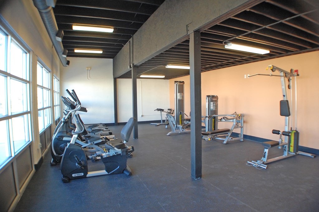a gym with cardio equipment and weights in a building