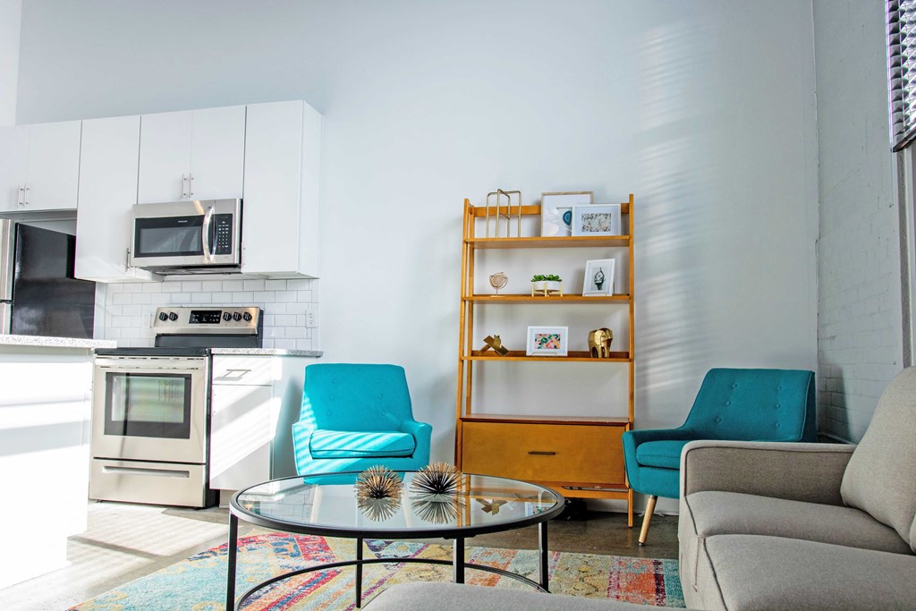 a living room with a kitchen and chairs and a table