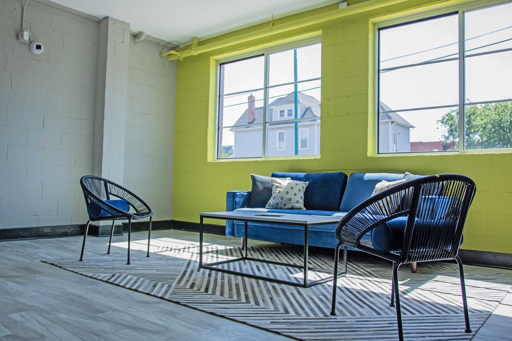 a living room with a couch and chairs and a rug