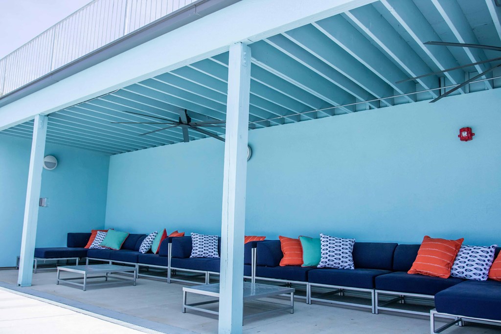 a group of couches and pillows in a room with a blue wall