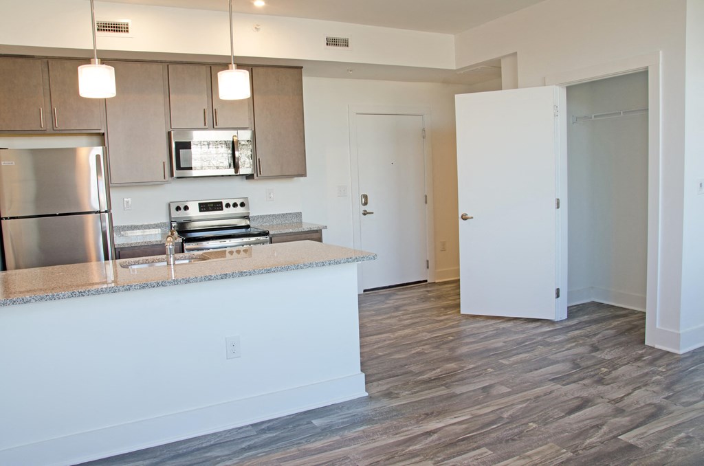 a kitchen with an island and a stainless steel refrigerator