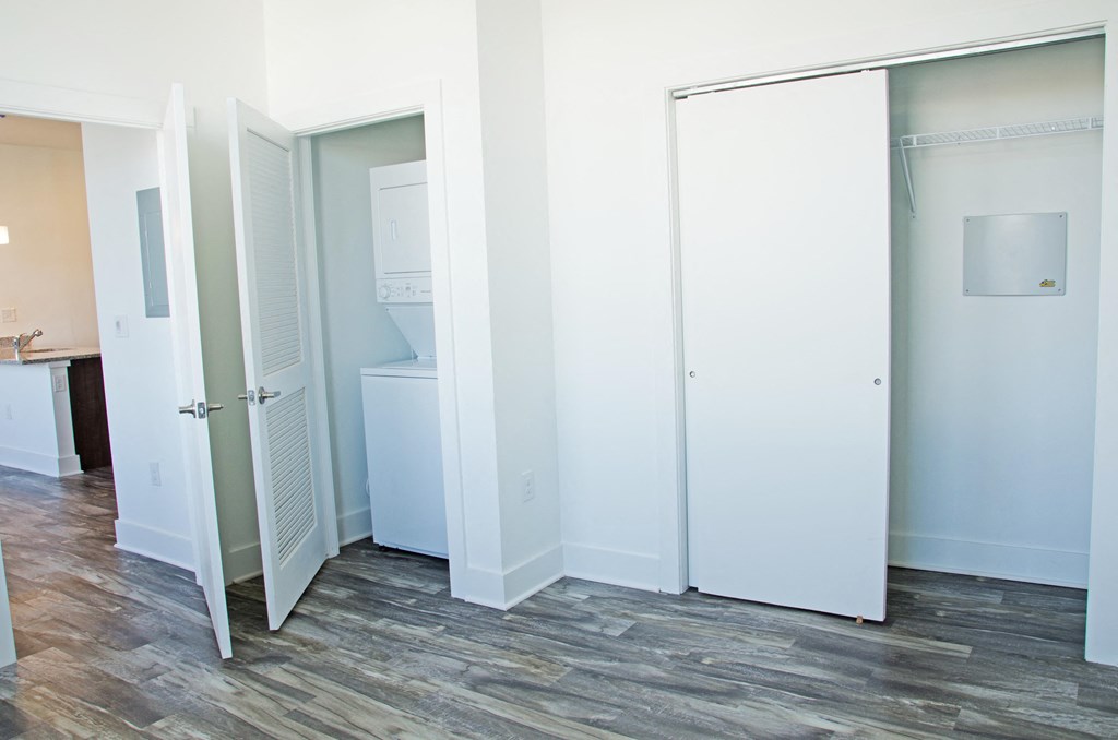 an empty room with three closet doors and a sink