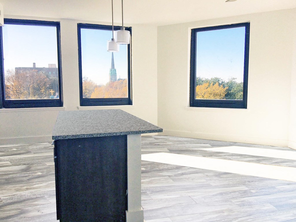 an empty room with a counter and three windows