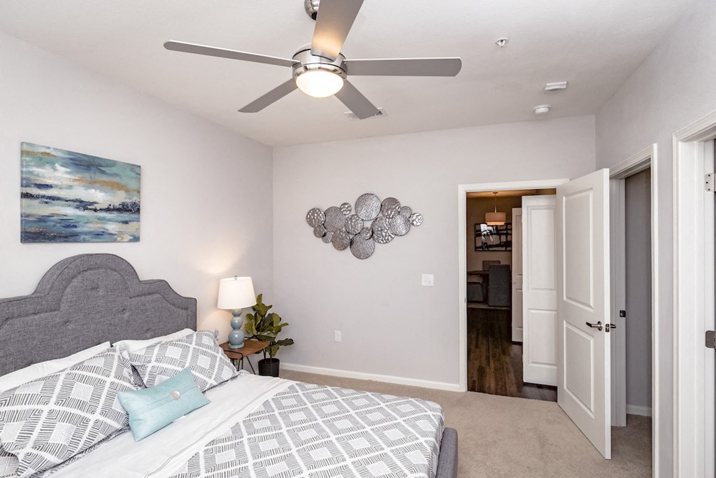 a bedroom with a large bed and a ceiling fan