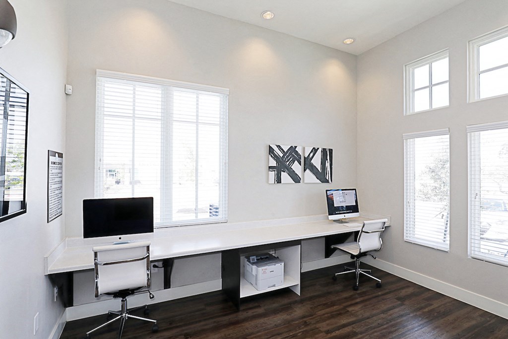 a home office with three windows and a desk with a computer