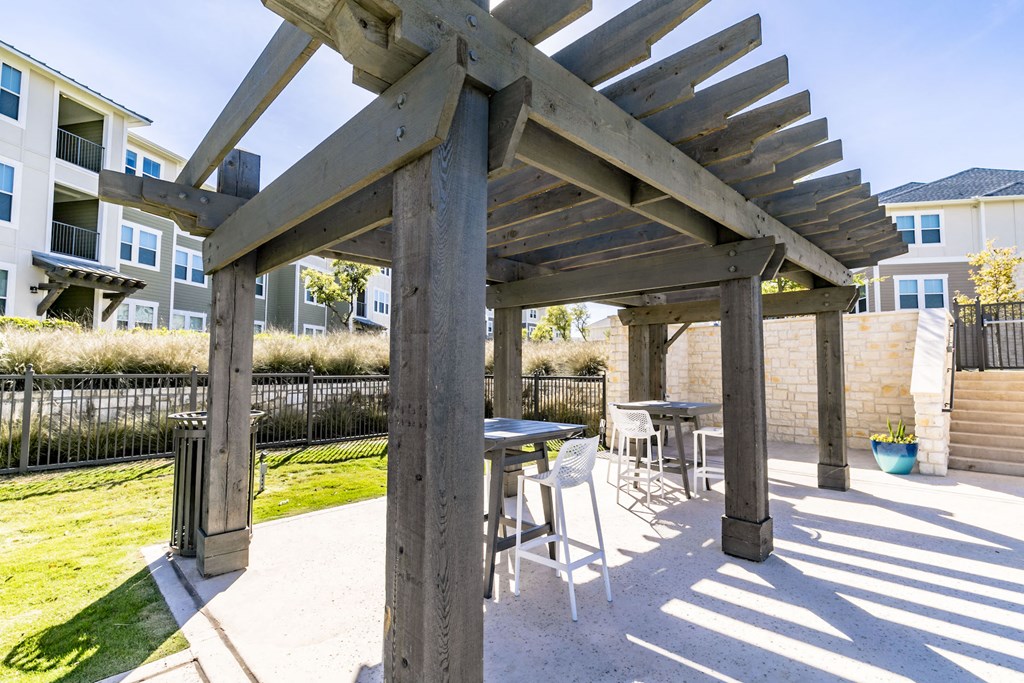 a patio with a table and chairs under a pergola