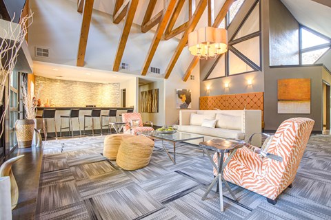 A living room with a white couch and a striped orange and white chair.