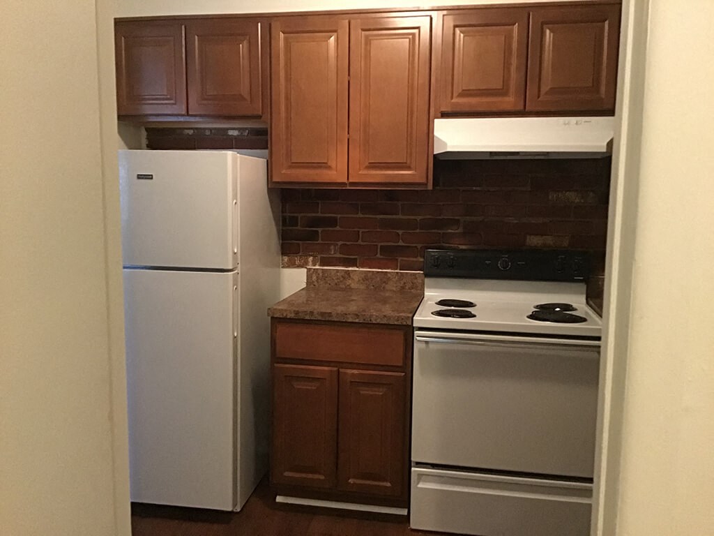 a kitchen with white appliances and brown cabinets
