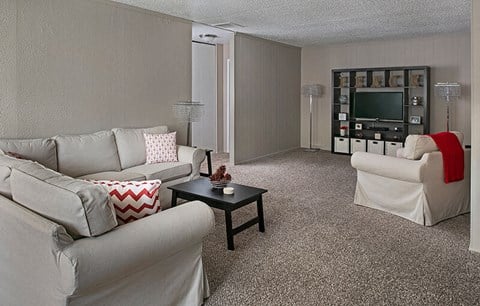 a living room with white furniture and a television