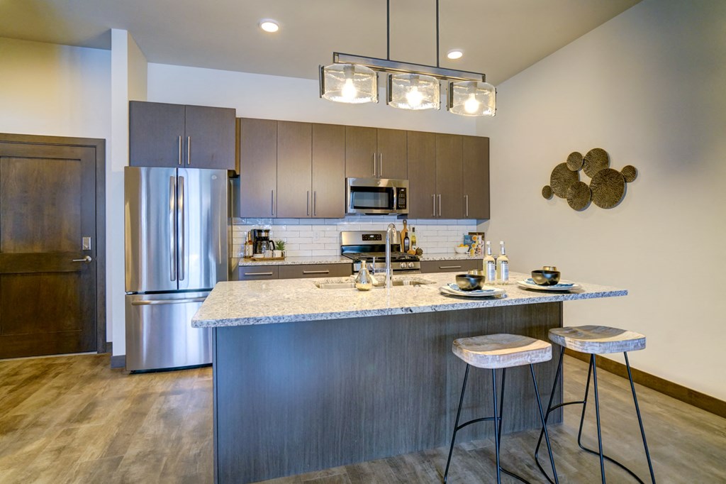 a kitchen with stainless steel appliances and a counter top with bar stools