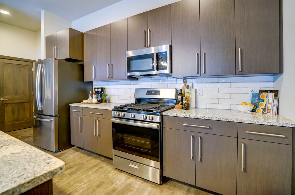 a kitchen with stainless steel appliances and granite counter tops
