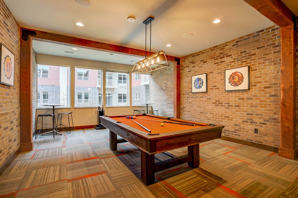 a game room with a pool table and brick walls