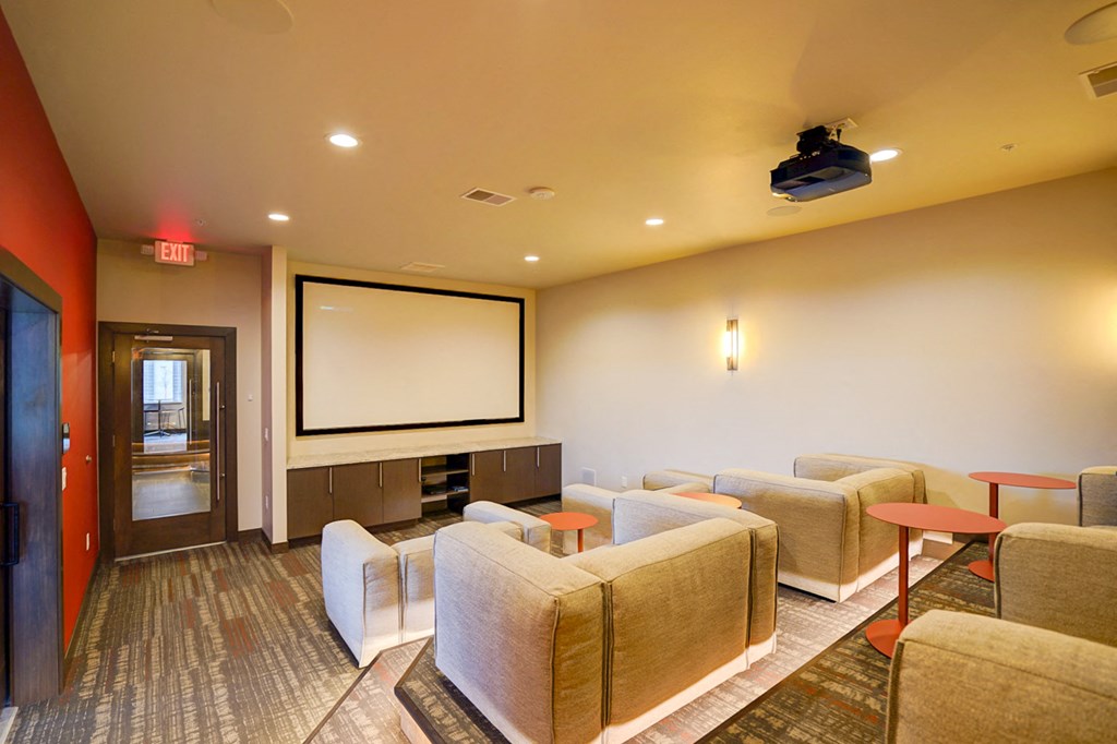 a large living room with couches and a screen on the wall