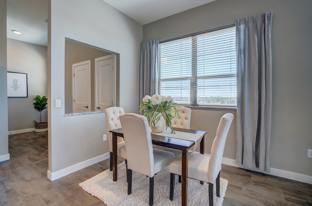 a dining room with a table and chairs and a window