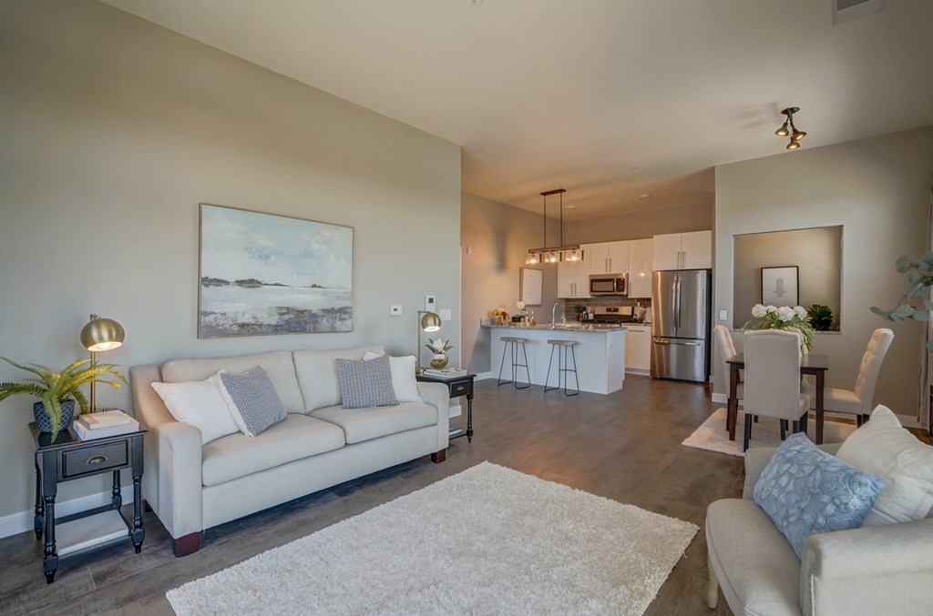 a living room and kitchen with a couch and a table