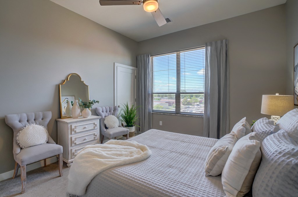 a bedroom with a bed and a dresser and a window