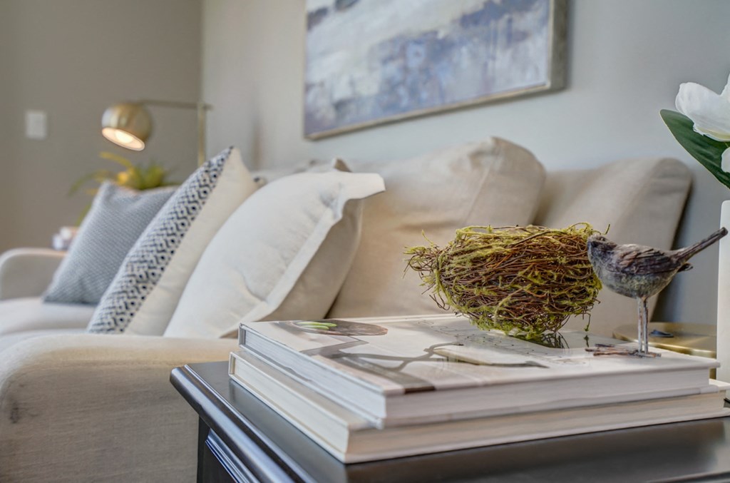 a living room with a couch and a table with a stack of books