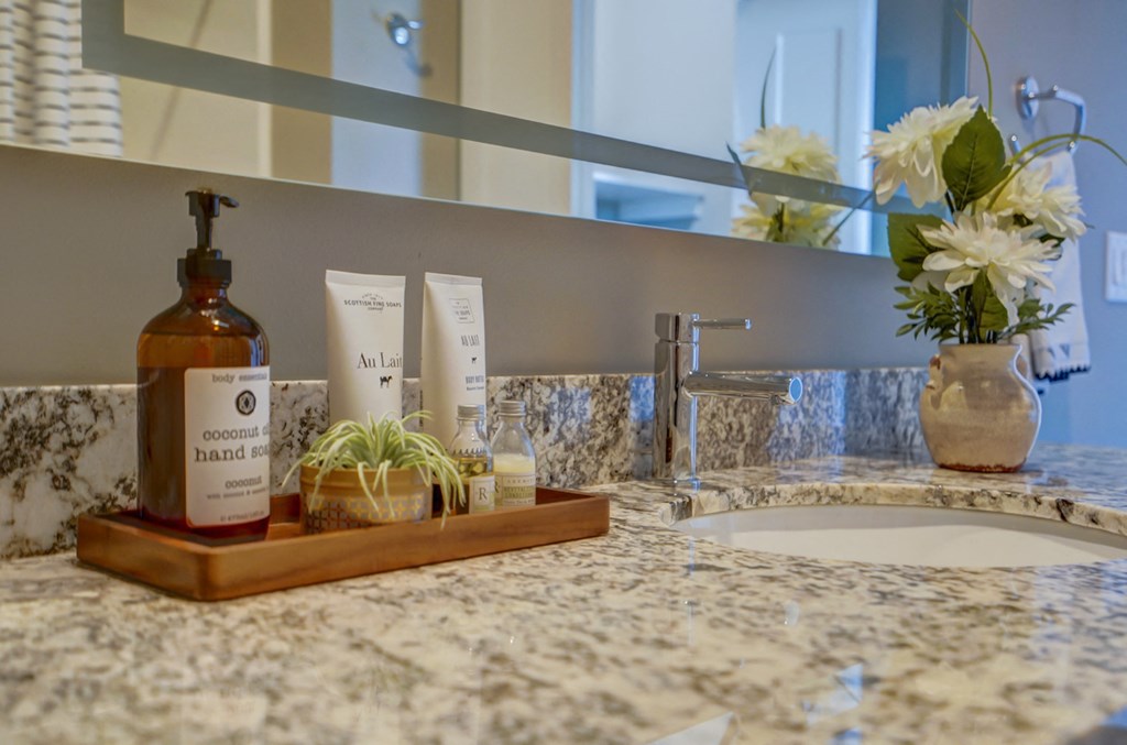 a bathroom with a sink and a tray of toiletries on a counter