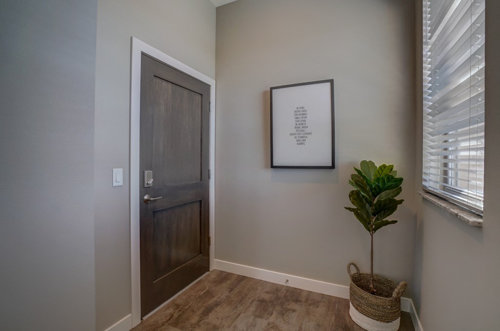 an empty room with a door and a plant in the corner