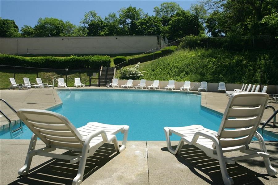 a pool with rocking chairs and chairs around it