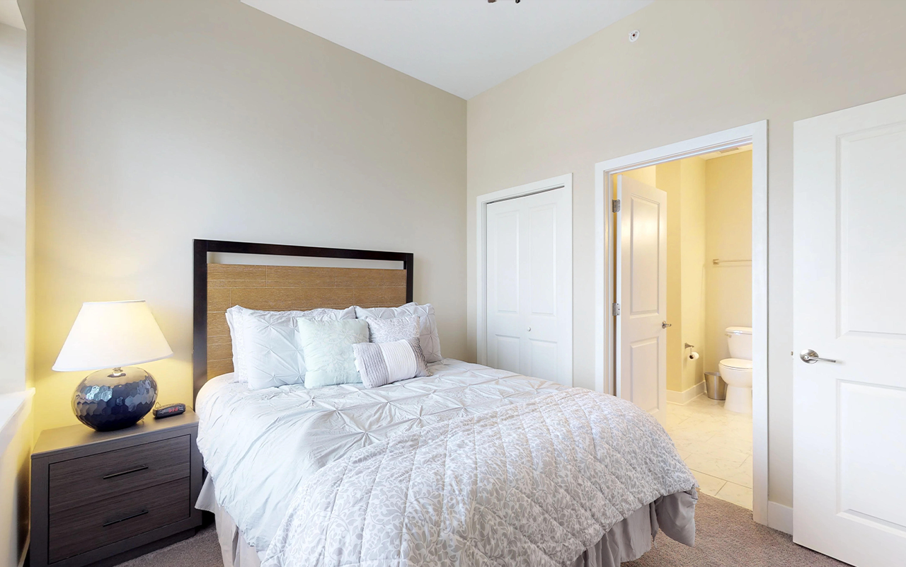 a bedroom with a bed and a door to a bathroom