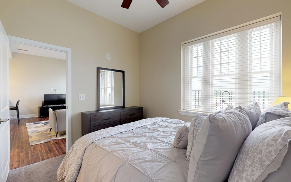 a bedroom with a large bed and a mirror on the wall