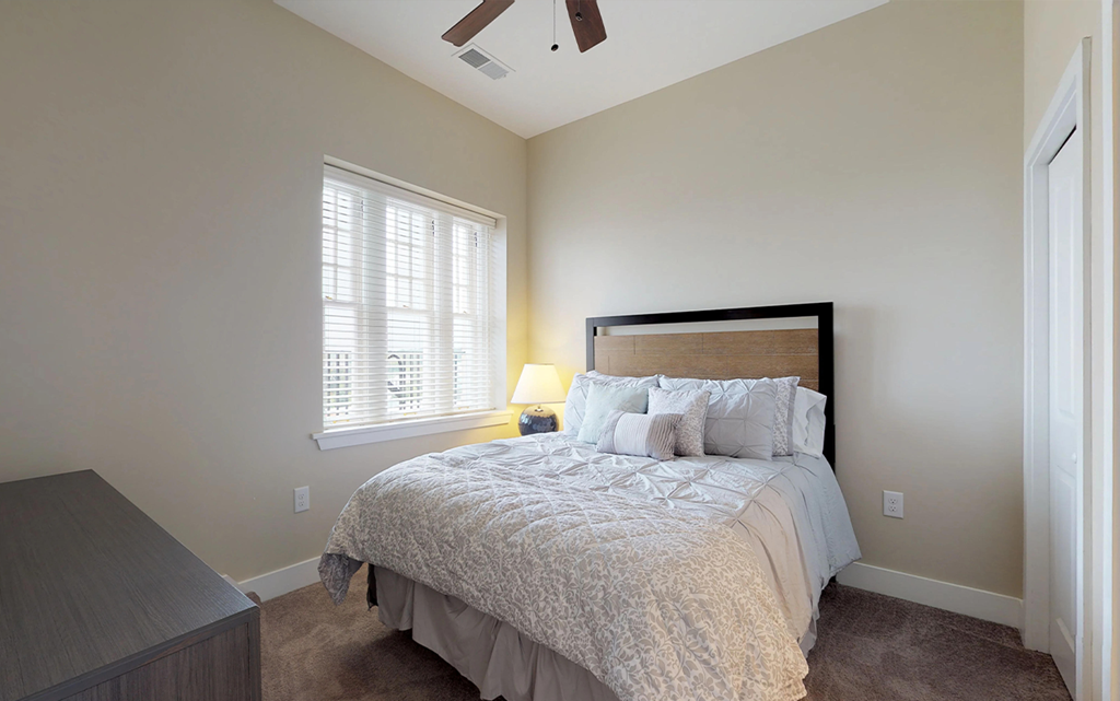 a bedroom with a bed and a window