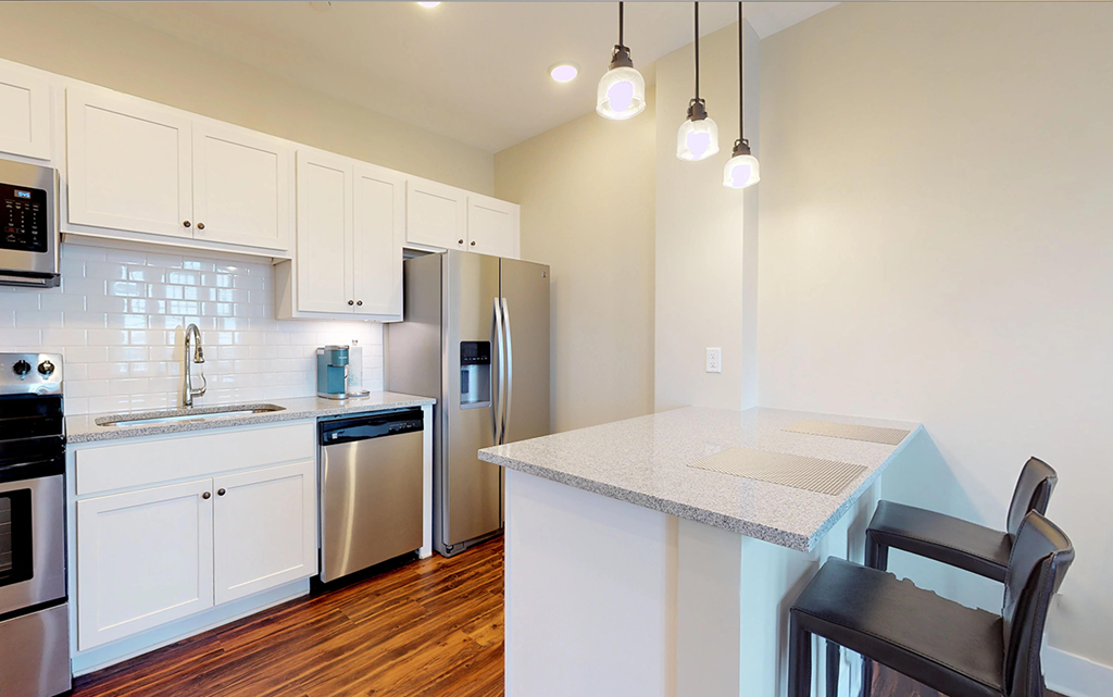a kitchen with an island and a stainless steel refrigerator