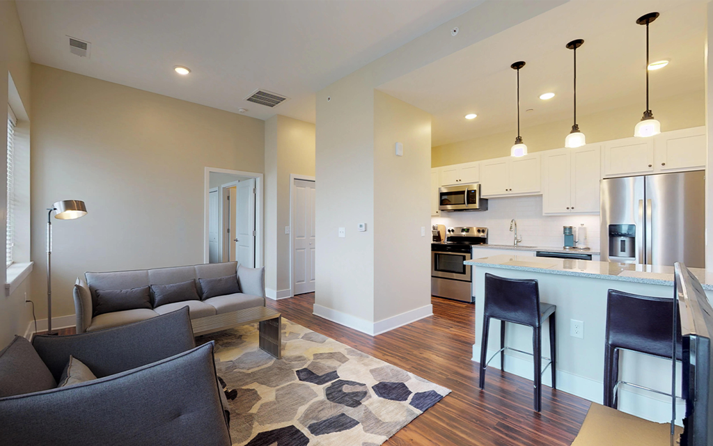 a living room and kitchen with a couch and a table