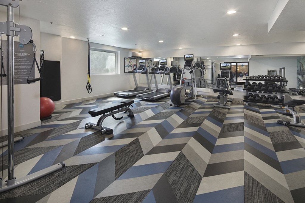 a gym with cardio machines and weights on the floor