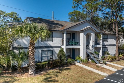 A house with a palm tree in front.