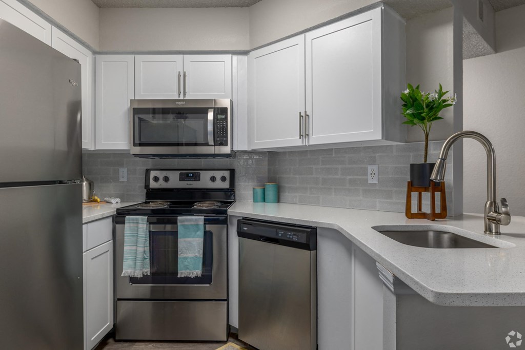 A modern kitchen with stainless steel appliances and white cabinets.