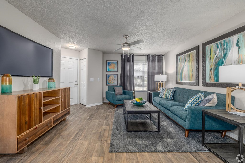 A living room with a blue couch and a wooden cabinet.