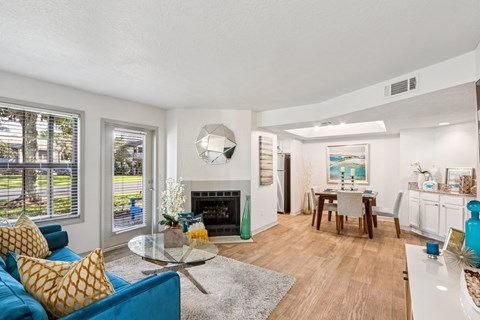 A living room with a blue couch and a fireplace.