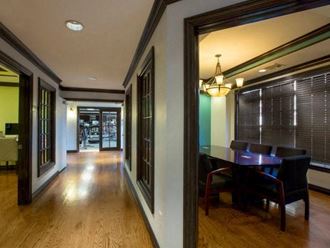 a long hallway with a dining room table and chairs