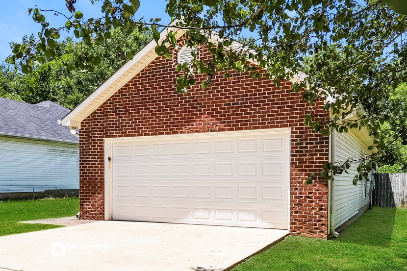 a red brick garage with a white garage door