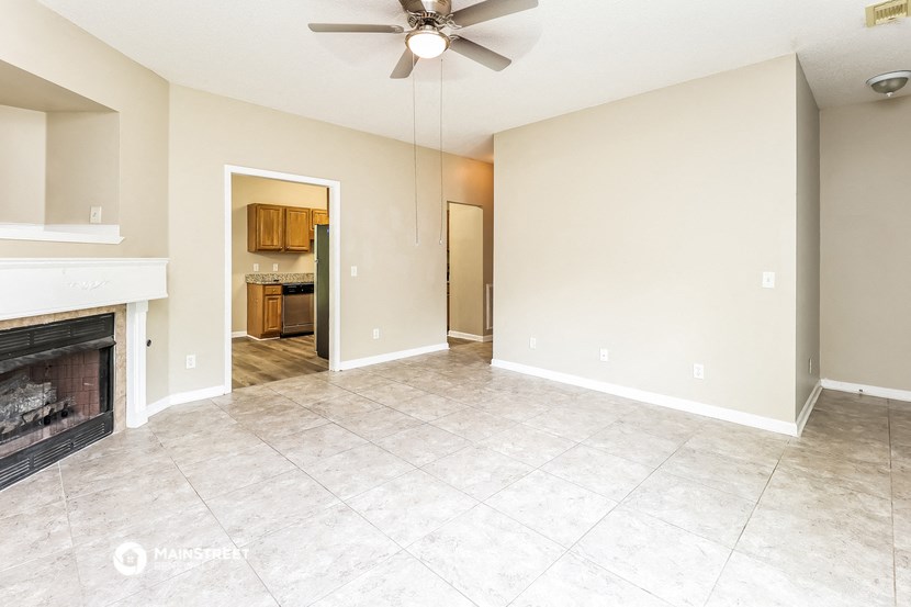 an empty living room with a fireplace and a tile floor