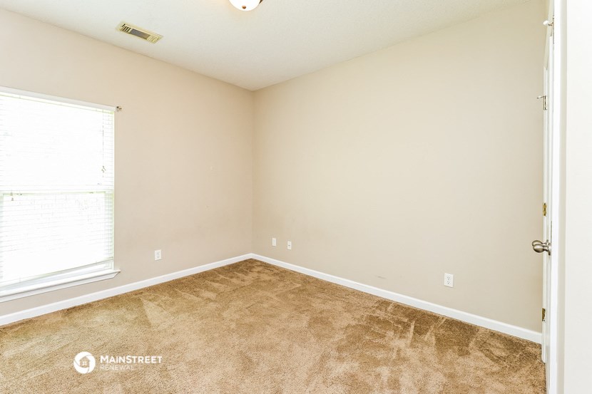the upstairs bedroom has carpeted floors and a large window