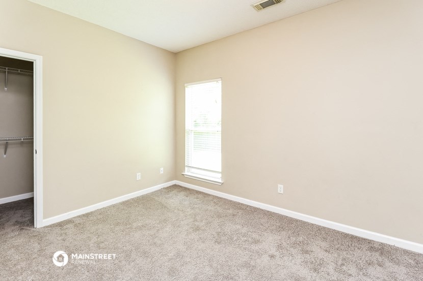 a room with carpet and a window and a closet