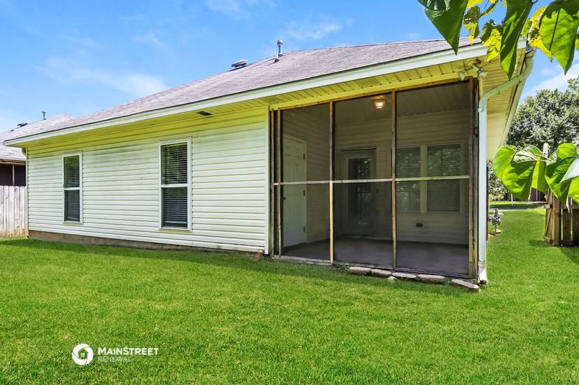 a white house with a porch with glass doors
