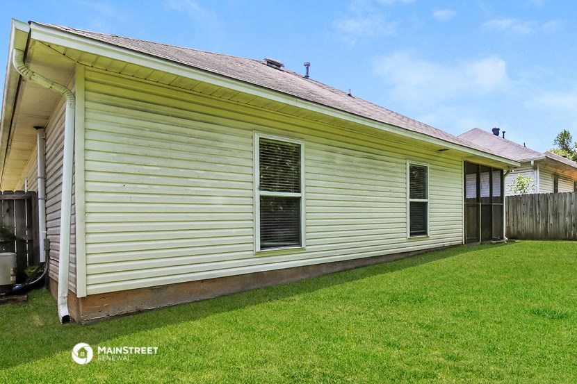the side of a yellow and with a grassy yard