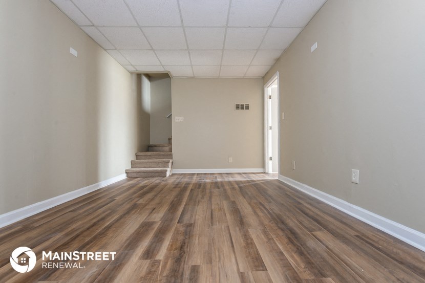 the interior of an empty room with wooden floors and white walls