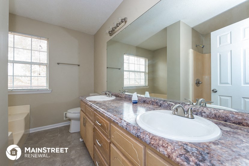 a bathroom with two sinks and a toilet and a mirror