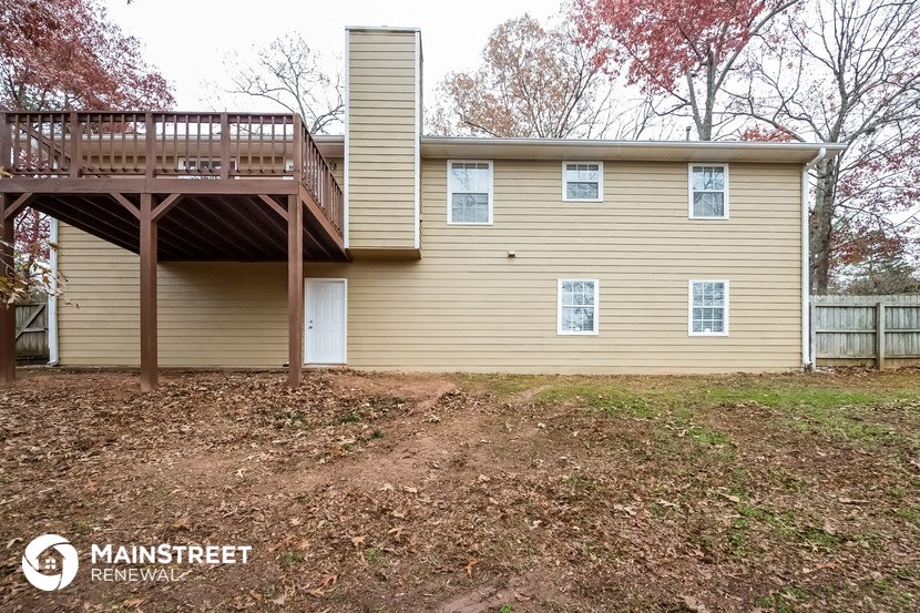 the back of a house with a deck on top of it