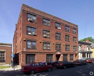 a red brick building with cars parked in front of it